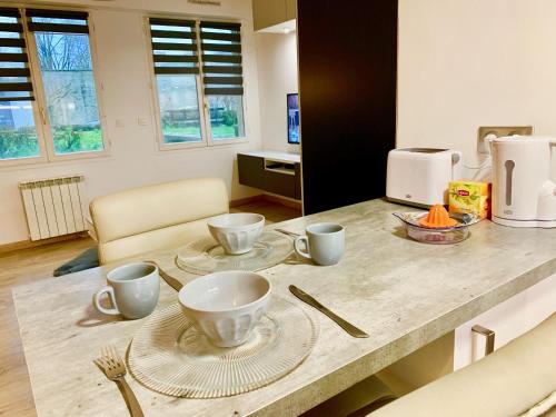 a kitchen counter with cups and plates on it at La charmeraie in Compiègne