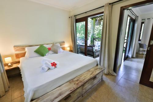 a bedroom with a large white bed with flowers on it at Recanto da Mata Pipa in Pipa