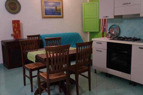 a kitchen with a table and chairs and a table and a stove at Castelletto Verde in Bari Sardo