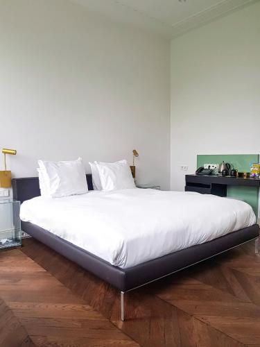 a large bed with white sheets and pillows in a bedroom at Parc Broekhuizen l Culinair landgoed in Leersum