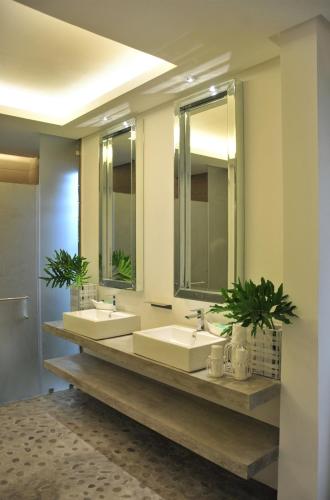 a bathroom with two sinks and two mirrors at Astoria Palawan in Puerto Princesa City