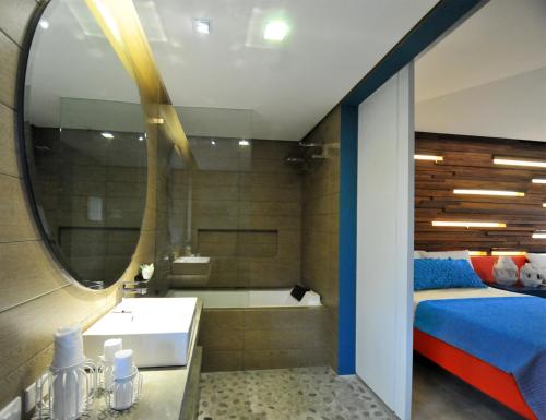 a bathroom with a bed and a tub and a sink at Astoria Palawan in Puerto Princesa City