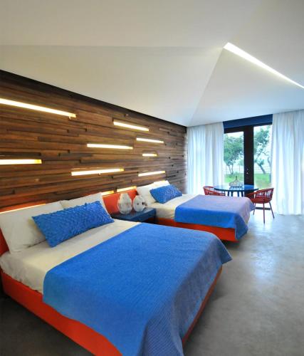 a bedroom with two beds and a table and chairs at Astoria Palawan in Puerto Princesa City