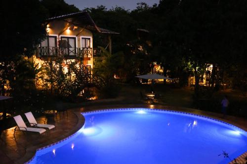 a swimming pool in front of a house at night at Recanto da Mata Pipa in Pipa