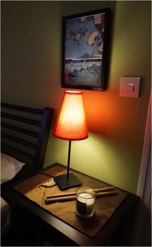 a lamp on a table next to a bed at Les Centauris in Pléguien