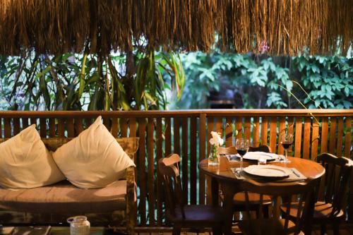 a table and a couch on a porch with a table and chairs at Recanto da Mata Pipa in Pipa