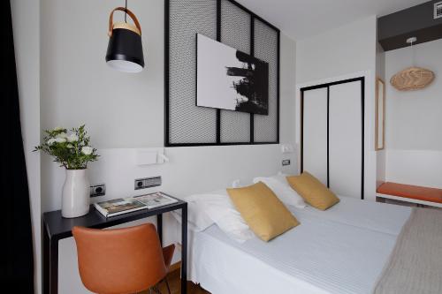 a bedroom with a bed and a table with a chair at Hotel Marqués, Blue Hoteles in Gijón