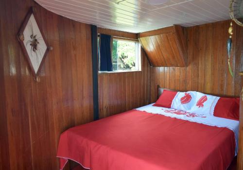 a bedroom with a red bed in a boat at Selvagem Tours in Alter do Chao