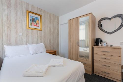 a bedroom with a white bed and a mirror at The Sandringham Court Hotel & Apartment Welcoming Large and Small Groups for 15 years in Blackpool
