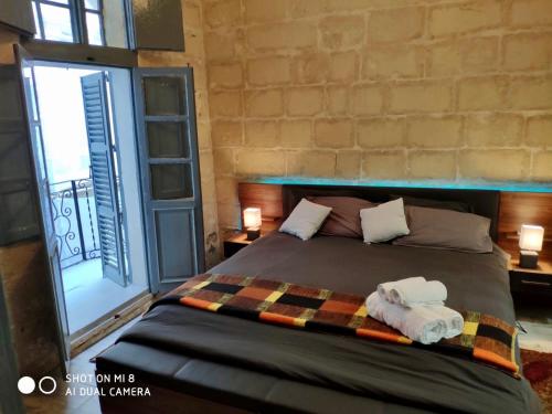ein Schlafzimmer mit einem Bett mit zwei Handtüchern darauf in der Unterkunft 16 Agius de Soldanis in Victoria