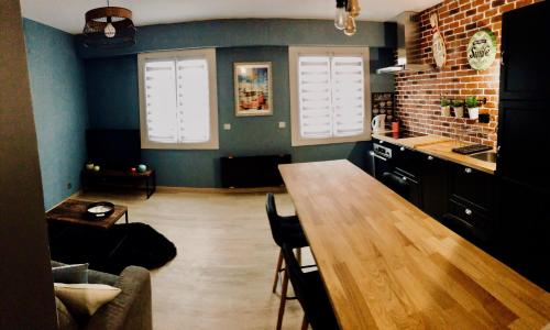 a kitchen with a wooden table in a room at La charmeraie in Compiègne