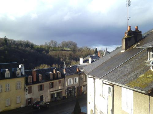 a group of buildings in a town with a mountain at Le trou dans le mur in Uzerche