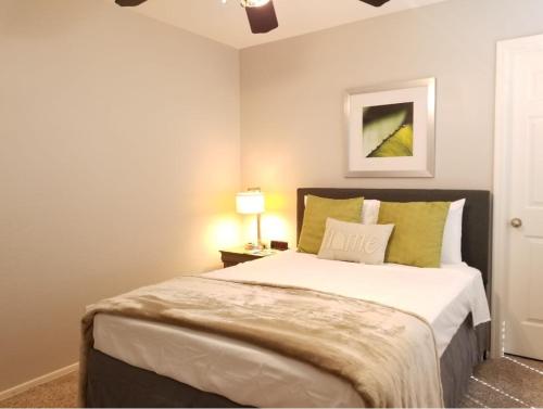 a bedroom with a large bed with green pillows at Phoenix I, Minutes to Airport and Downtown in Phoenix