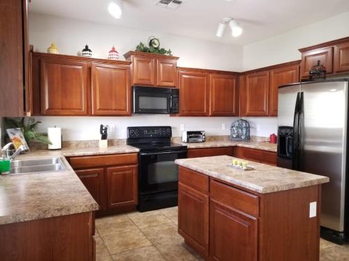 a kitchen with wooden cabinets and a stainless steel refrigerator at Phoenix I, Minutes to Airport and Downtown in Phoenix