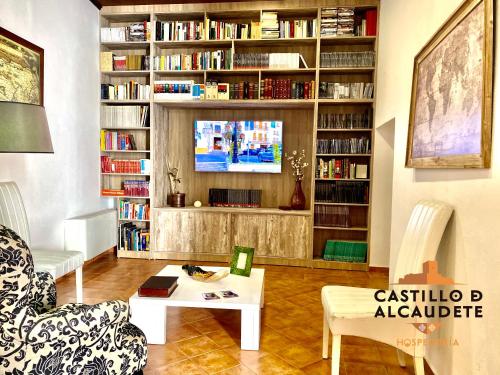 sala de estar con sofá, mesa y TV en HOSPEDERÍA CASTILLO DE ALCAUDETE, en Alcaudete