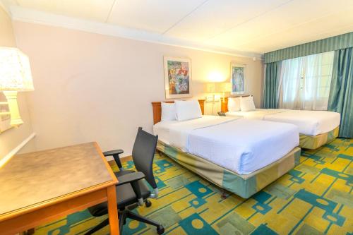 Clute的住宿－克魯特傑克遜湖拉奎塔酒店，酒店客房配有两张床和一张书桌