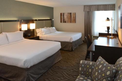 Habitación de hotel con 2 camas y escritorio en Holiday Inn Youngstown-South - Boardman, an IHG Hotel en Boardman