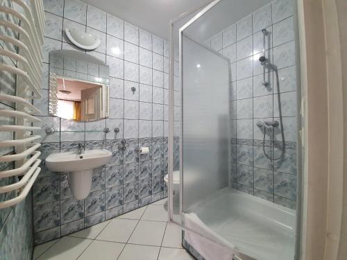 a bathroom with a shower and a sink at Jantar in Polanica-Zdrój
