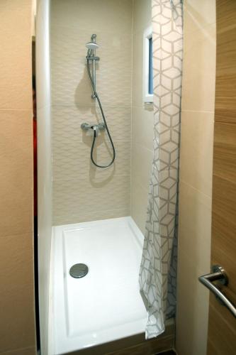 une salle de bain avec une douche avec un rideau de douche dans l'établissement Le jardin du port, à Nice