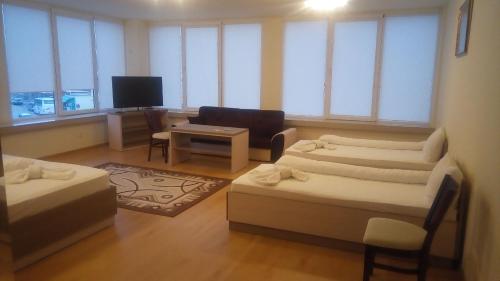 a living room with two beds and a tv at Hotel Lago Peshtera in Peshtera