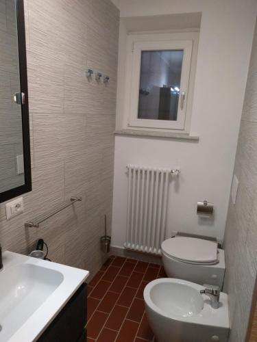 a bathroom with a white toilet and a sink at "La Selvetta" bed and breakfast in Buguggiate