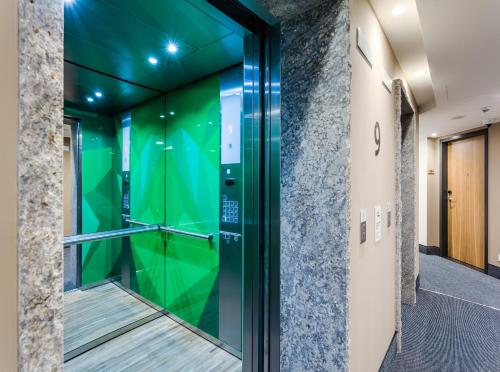 eine Glastür in einem Gebäude mit einer grünen Wand in der Unterkunft Holiday Inn - Warsaw City Centre by IHG in Warschau