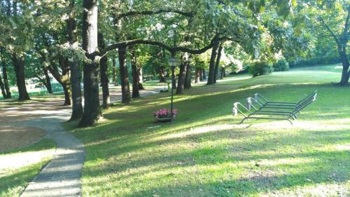 a park with two park benches in the grass at "La Selvetta" bed and breakfast in Buguggiate