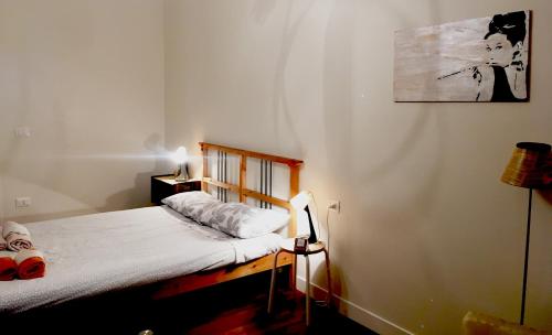 a bedroom with a bed and a picture on the wall at A casa di Nat in Modena
