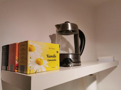 two books on a shelf with a tea kettle at Zentrale, ruhige Wohnung nahe Murinsel & Kunsthaus in Graz