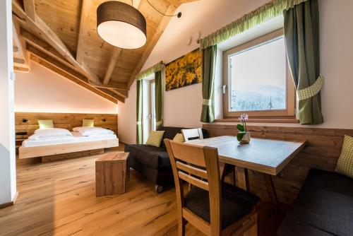 a bedroom with a bed and a table in a room at Rauchenbichlerhof in Brunico