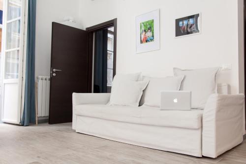a white couch in a living room with a laptop at NIU LUX Apartments in Genoa