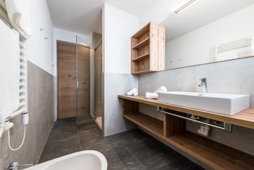 a bathroom with a sink and a shower at Rauchenbichlerhof in Brunico