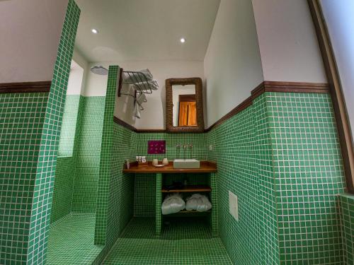 a green tiled bathroom with a sink and a mirror at Casa de Isabella, a Kali Hotel in Santa Marta