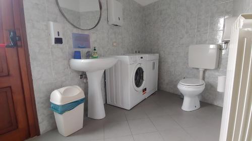 a bathroom with a washing machine and a sink at Ostello del Parco di Cicogna in Cicogna