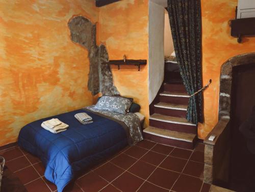 1 dormitorio con cama y escalera en La grotta del ghetto, en Pitigliano
