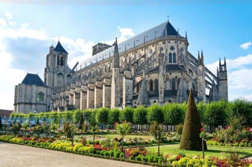 ein großes Gebäude mit einem Garten davor in der Unterkunft Calme et au cœur du centre historique in Bourges