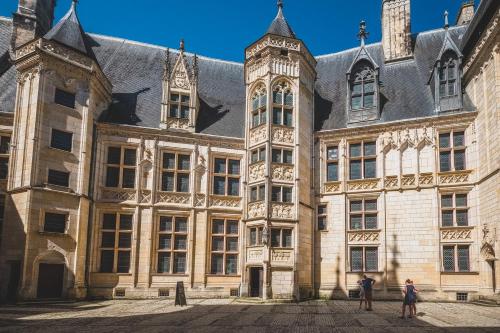 duas pessoas em frente a um grande edifício em Calme et au cœur du centre historique em Bourges