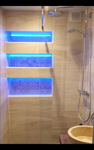 La salle de bains est pourvue d'une douche avec des lumières bleues. dans l'établissement Calme et au cœur du centre historique, à Bourges