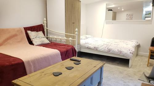 a living room with two beds and a coffee table at Urban Log Cabin near zone 2 tube in London