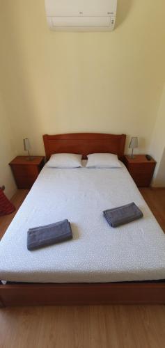 uma cama com duas almofadas em cima em Margarida Guest House - Rooms em Almada