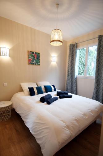 une chambre avec un grand lit blanc avec des oreillers bleus dans l'établissement Le jardin du port, à Nice