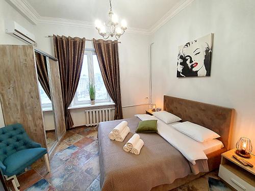キーウにあるInn Home Apartments - Kreshchatyk areaのベッドルーム(大型ベッド1台、青い椅子付)