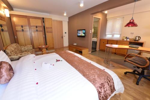 a large white bed in a room with a desk at Hanoi Golden Sunshine Villa Hotel and Travel in Hanoi