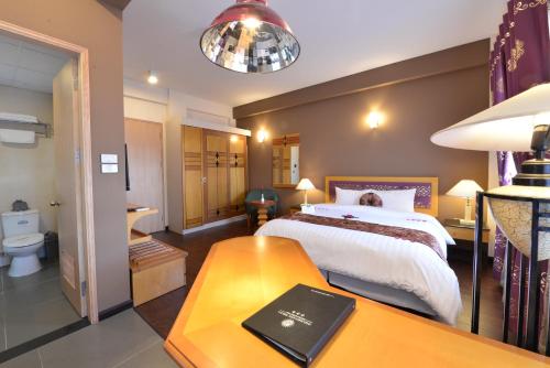 a bedroom with a bed and a table with a book on it at Hanoi Golden Sunshine Villa Hotel and Travel in Hanoi
