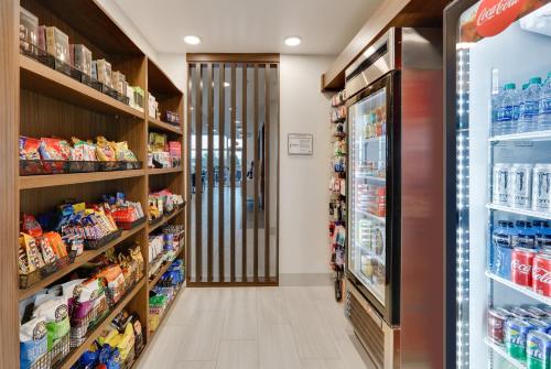 a aisle of a grocery store with a refrigerator at Holiday Inn Express & Suites Plano East - Richardson by IHG in Plano