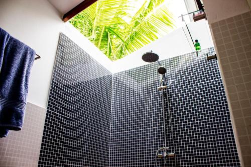 a bathroom with a shower with a window at Holiday Cottage Thoddoo, Maldives in Thoddoo