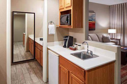 a kitchen with a sink and a living room at Orchards Inn in Sedona
