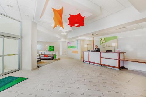 a lobby with a person standing at a counter in a building at Holiday Inn Sydney - Waterfront by IHG in Sydney
