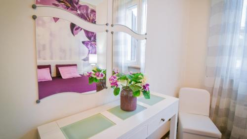 łazienka z lustrem i kwiatami na ladzie w obiekcie Casa Sant Elena ID15675 w mieście Peschiera del Garda