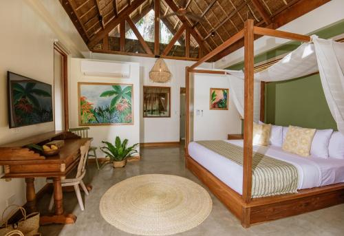 a bedroom with a canopy bed and a piano at Las Palmas Villas and Casitas Siargao in General Luna